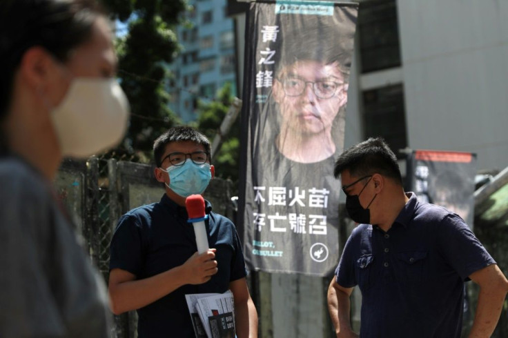 Pro-democracy activist Joshua Wong (C) campaigns for the primary which will choose candidates for upcoming legislative elections