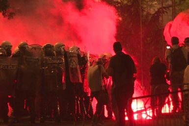 Protesters hurl firecrackers and flares at police in a fourth night of demonstrations in Belgrade