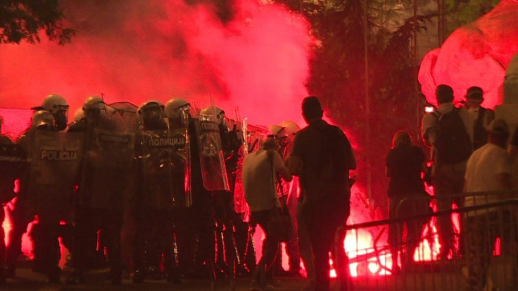 Protesters hurl firecrackers and flares at police in a fourth night of demonstrations in Belgrade