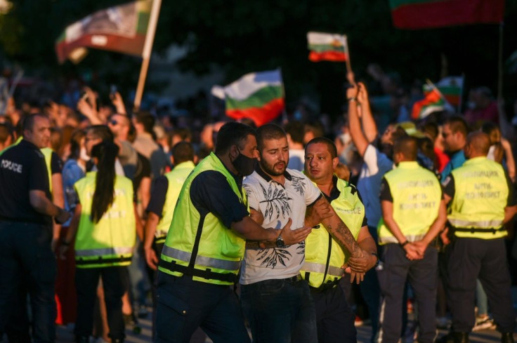 A protester is detained by police during an anti-government rally