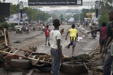 Protesters run from riot police after erecting barricades to block the Martyrs Bridge in Bamako on Saturday