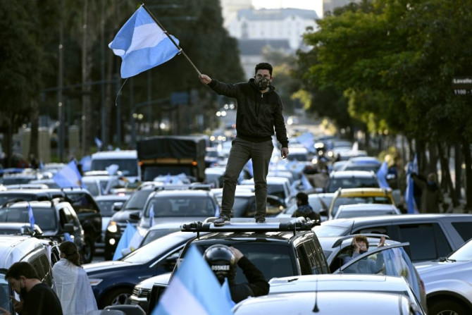 A man waves the Argentine flag during a protest against President Alberto Fernandez's health policies during the coronavirus pandemic in Buenos Aires on July 9, 2020