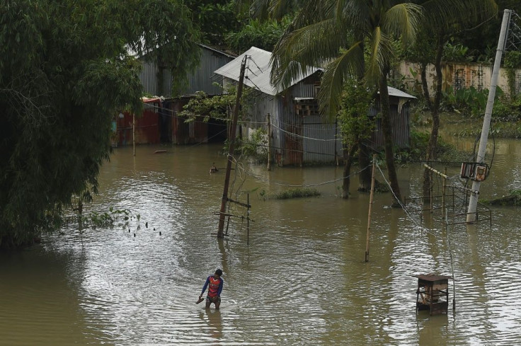 A man wades through a flooded village in in Bangladesh, where a third of the country is underwater