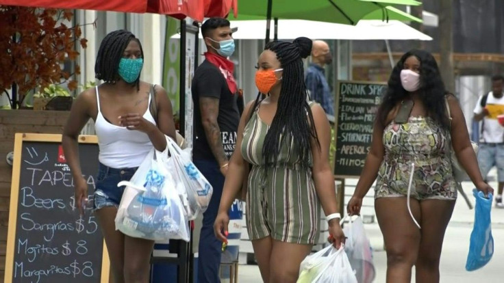 People in Miami wear face masks, as Florida reports record number of new cases of the coronavirus.