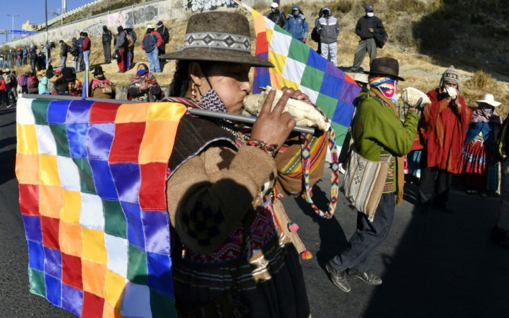 Bolivian demonstrators blew large sea shell horns known as "pututus" during a march against the government of interim President Jeanine Anez