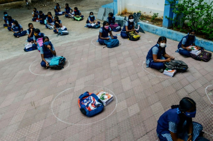 Students in Chennai keep their distance while waiting to collect course materials before heading home to begin online lessons