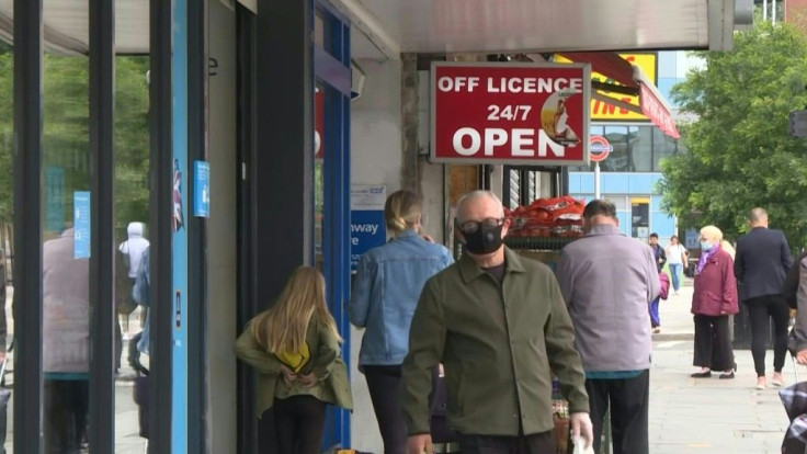 Londoners react after the British government's announcement that facemasks would be compulsory in shops and supermarkets in England from next week, in a U-turn on previous policy.