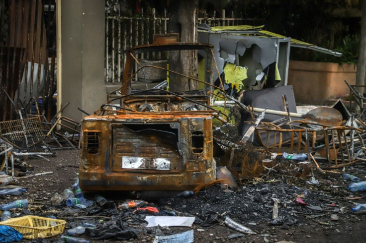 On a main road into town, businesses have been looted and burnt black, their front windows shattered, their walkways covered in twisted scrap metal