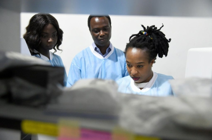 Laboratory manager Philomena Eromon, right, joins molecular biologists to analyse coronavirus samples