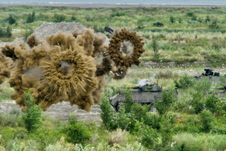 Armoured vehicles launch smoke grenades near Taichung during the exercises