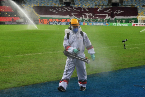 A worker disinfects the pitch at half time during the Rio de Janeiro state championship football final match between Flamengo and Fluminense at Maracana stadium, Rio de Janeiro, Brazil on July 15, 2020