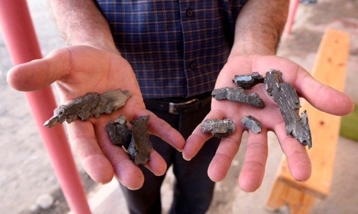 A man shows an artillery shell fragments in a  village in the Tovuz district of Azerbaijan