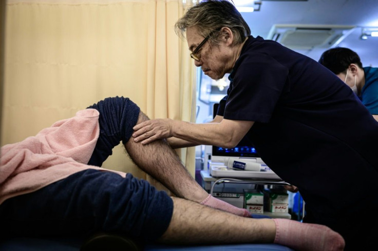 Hiroyuki Mitsuhashi, who uses 'judo therapy', treats a rugby player at his Tokyo clinic