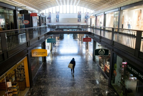 The US economy suffered a 37 percent collapse in GDP in the second quarter -- here, a woman walks through an empty shopping area in Washington in March 2020