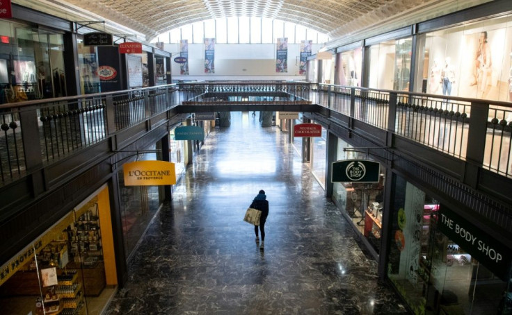 The US economy suffered a 37 percent collapse in GDP in the second quarter -- here, a woman walks through an empty shopping area in Washington in March 2020