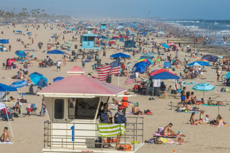 People enjoy the waves in Huntington Beach, California on June 14, 2020