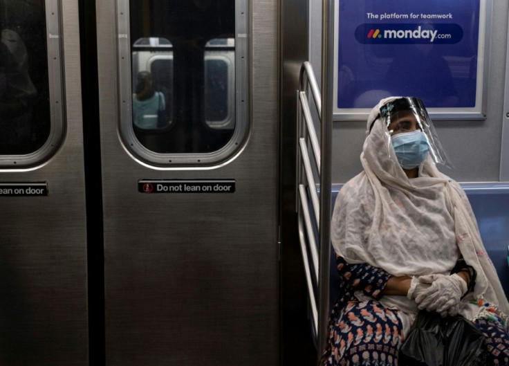 A woman wearing a face mask and shield sits in a New York subway train during rush hour amid the coronavirus pandemic on July 16, 2020; as many people turn away from mass transit, bicycle use has exploded