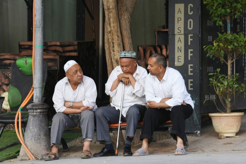 Uighur men resing in front of a coffee bar in Kashgar, western Xinjiang. China denies abusing the Uighur population and says such accusations are slander