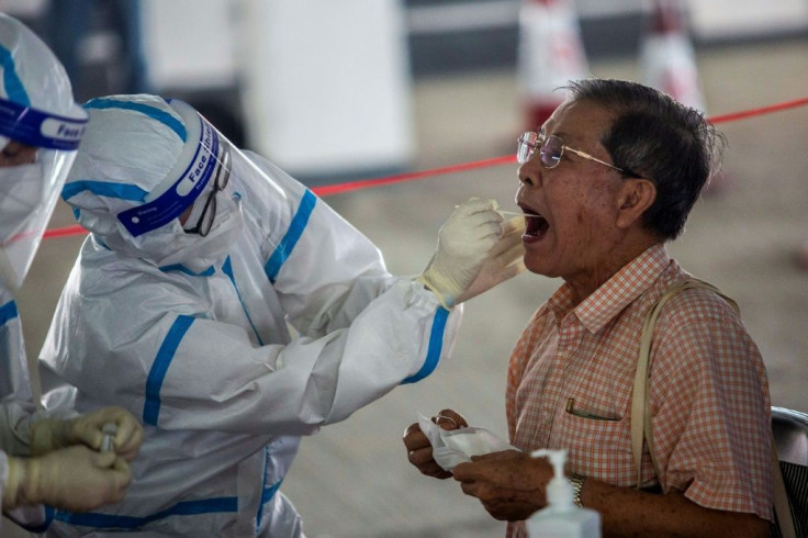 A taxi driver is tested by health workers in a carpark in Hong Kong