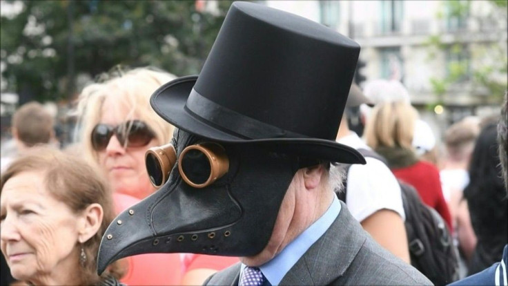 People gather in London to protest against the UK government's decision to require people to wear face masks in shops and supermarkets in England.