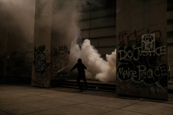 Protestors run after law enforcment fire tear gas on the steps of the US District Court building in Portland, Oregon