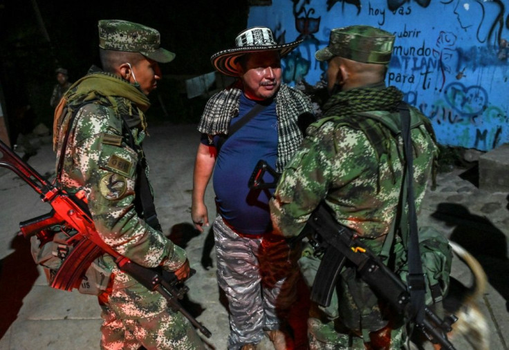 Former FARC guerilla commander Juan de Dios Quintero, aka Panico, talks to Colombian soldiers the night before the group's evacuation to a new reintegration zone in Mutata