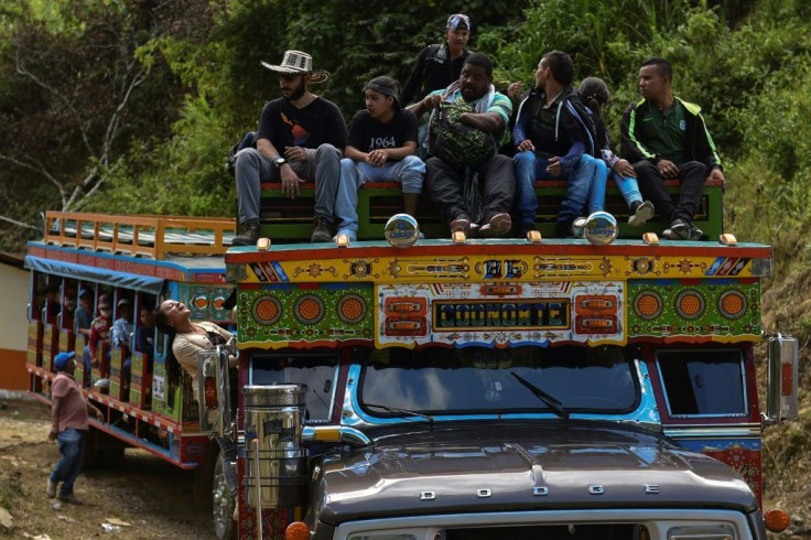 Former FARC guerrillas ride on traditional buses known as "chivas" on their way to a new reintegration zone in Mutata, in Antioquia department