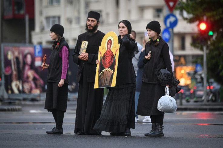 A Christian-Orthodox family holds an icon during a protest against the 'sanitary dictatorship'