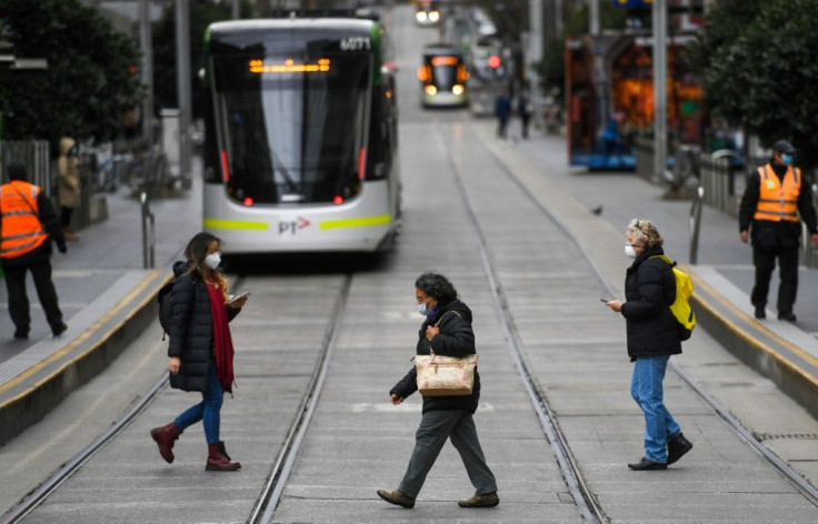 Pedestrians don masks as they walk the unusually quiet streets of central Melbourne