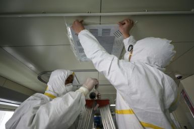 Hospital employees in Wuhan, China seal an airvent to prevent possible airborne transmission of the new coronavirus