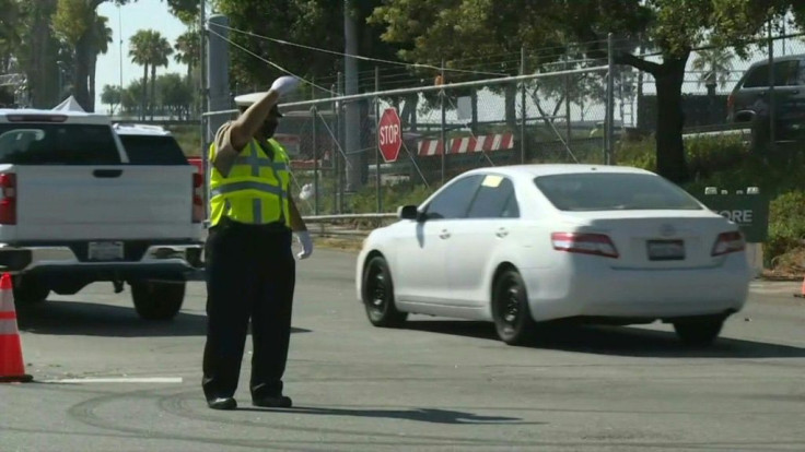 Vehicles move toward the entrance of Los Angeles' Dodger Stadium, which houses the busiest COVID-19 testing site in the United States, with about 6,500 tests administered daily