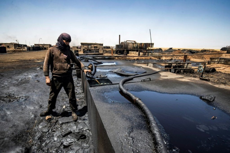 A man works at a makeshift refinery distilling crude oil in the village of Bishiriya in the countryside near Al-Qahtaniya in northeast Syria