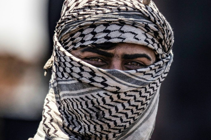 Workers at informal refineries cover their faces with scarves, to provide a degree of protection against skin complaints and other negative reactions to pollutants