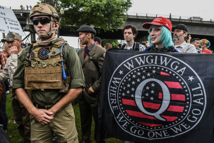 A person holds a banner for the Qanon conspiracy theory movement during an alt-right rally in Portland, Oregon in August 2019