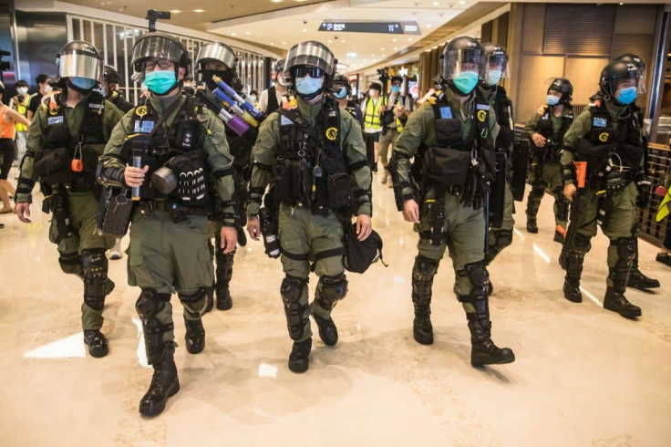 Riot police secure a shopping mall in Hong Kong after prostesters gathered to mark one year since a group of white-clad men attacked pro-democracy protesters in the mall
