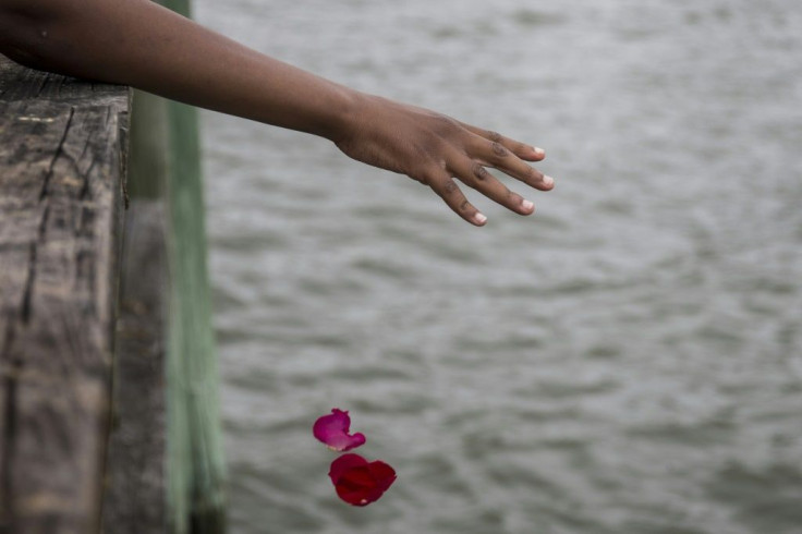 Guests take part in a flower petal throwing ceremony to honor Africans who passed away at sea during the Atlantic slave trade during the 2019 African Landing Commemorative Ceremony on August 24, 2019 in Hampton, Virginia