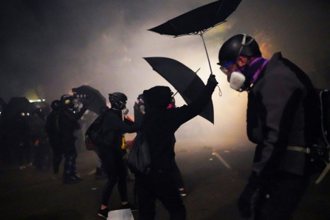 Protesters use umbrellas to block pepper balls while clashing with federal officers on July 22, 2020 in Portland, Oregon