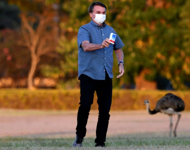 Brazilian President Jair Bolsonaro shows a box of hydroxychloroquine to supporters outside the Alvorada Palace in Brasilia