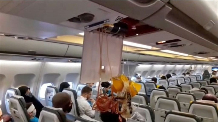 An oxygen mask dangles in the cabin of an Iranian passenger plane after it was intercepted by US jets while flying over Syria
