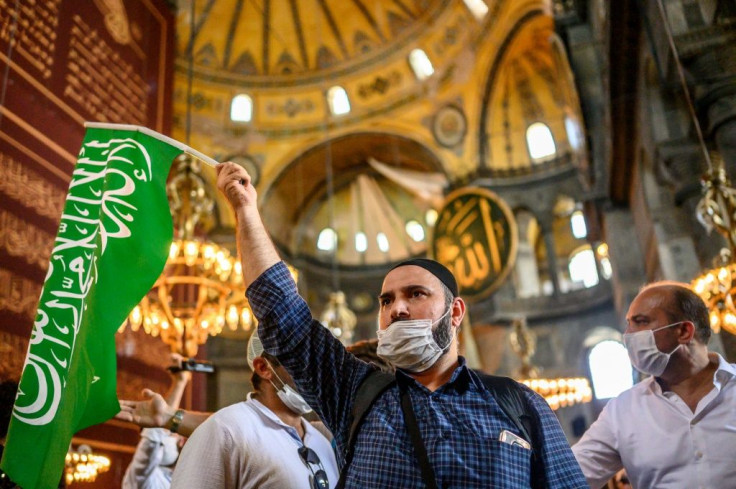 A worshipper holds an Islamic flag inside the mosque