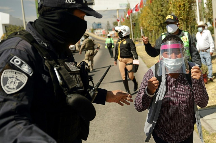 A policeman blocks Celia Capira as she tries to approach Peru's President Martin Vizcarra to plead for help in saving her husband's life as he struggles with coronavirus