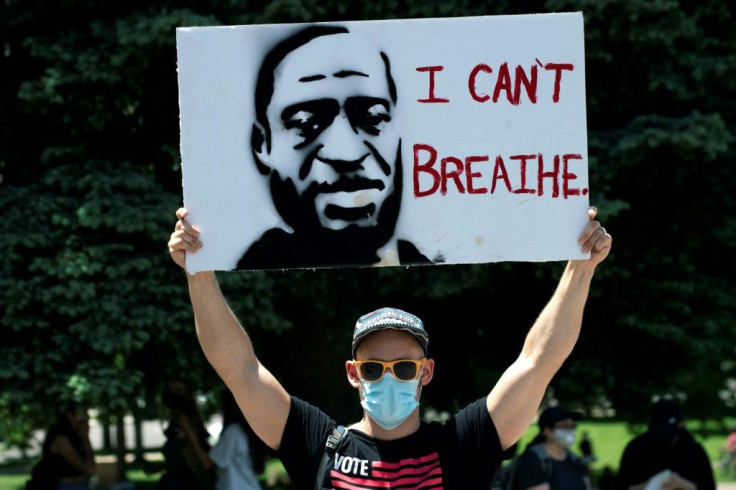 A demonstrator holds up a poster with a rendition of George Floyd on May 30 in Denver