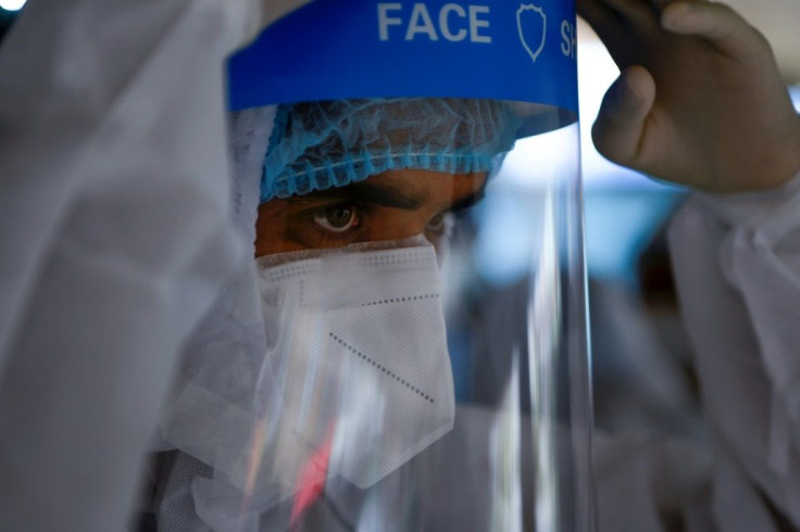 A health worker collects swab samples in the Mahaboudha area in Kathmandu