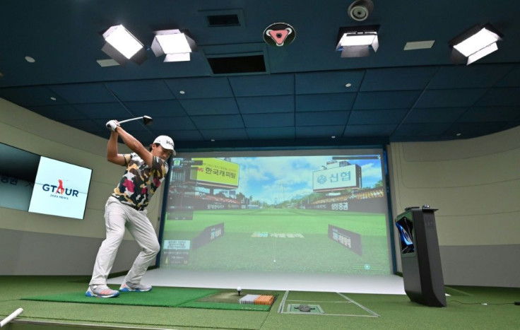 A South Korean golfer hits in a simulation booth during the GTour screen golf tournament in Daejeon, south of Seoul