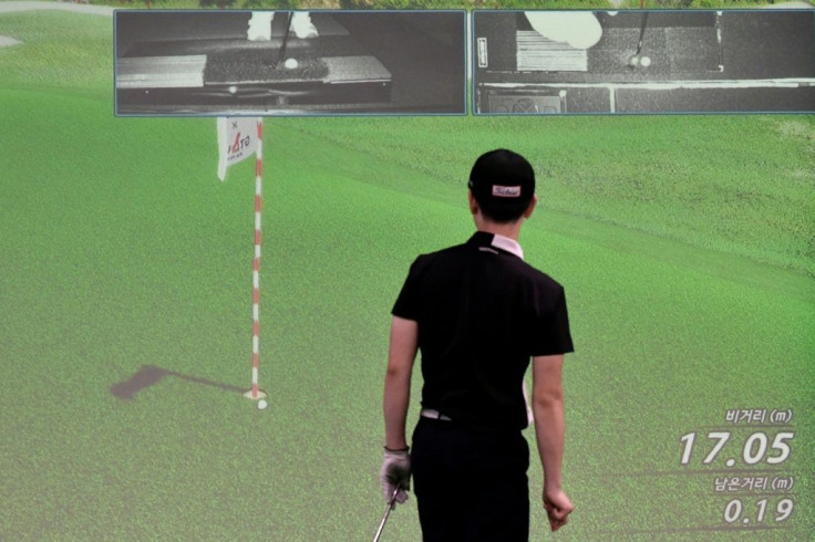 In the hole? A golfer watches his putt on a projected simulation during the GTour screen golf tournament in Daejeon, south of Seoul