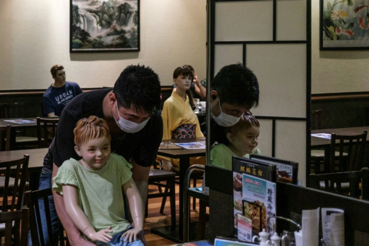 The mannequins range from women dressed in traditional Japanese and Chinese attire to smiling children