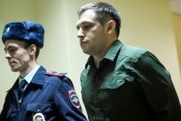 Police officers escort US ex-marine Trevor Reed, charged with attacking police, into a courtroom prior to a hearing in Moscow on March 11, 2020