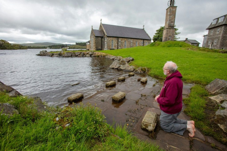 Father Flynn prays barefoot at the penitential beds where pilgrims normally come at  Lough Derg