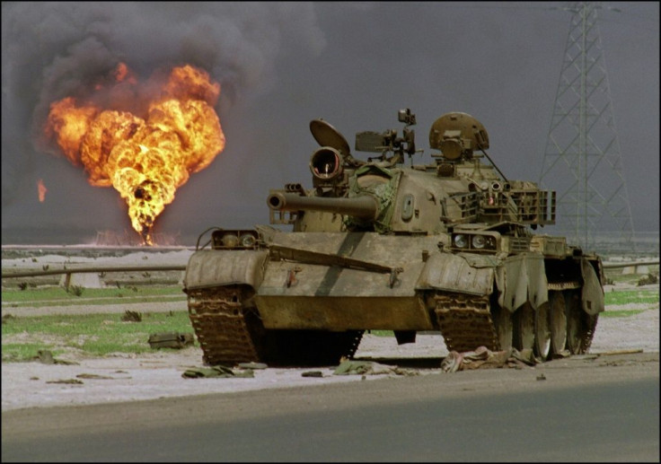 An abandoned Iraqi Soviet-made T-62 tank sits in the Kuwaiti desert as an oil well burns in the background, on April 2, 1991