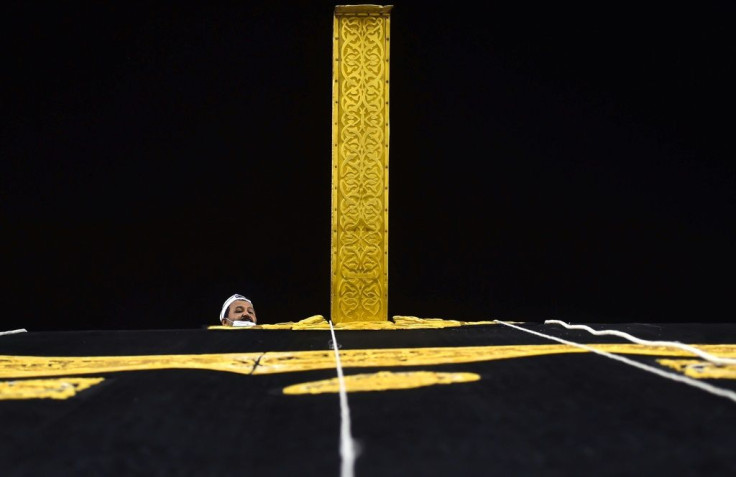 A Saudi workman adjusts the new kiswa, the gold-embroidered black cloth covering the Kaaba, that is changed during each year's hajj